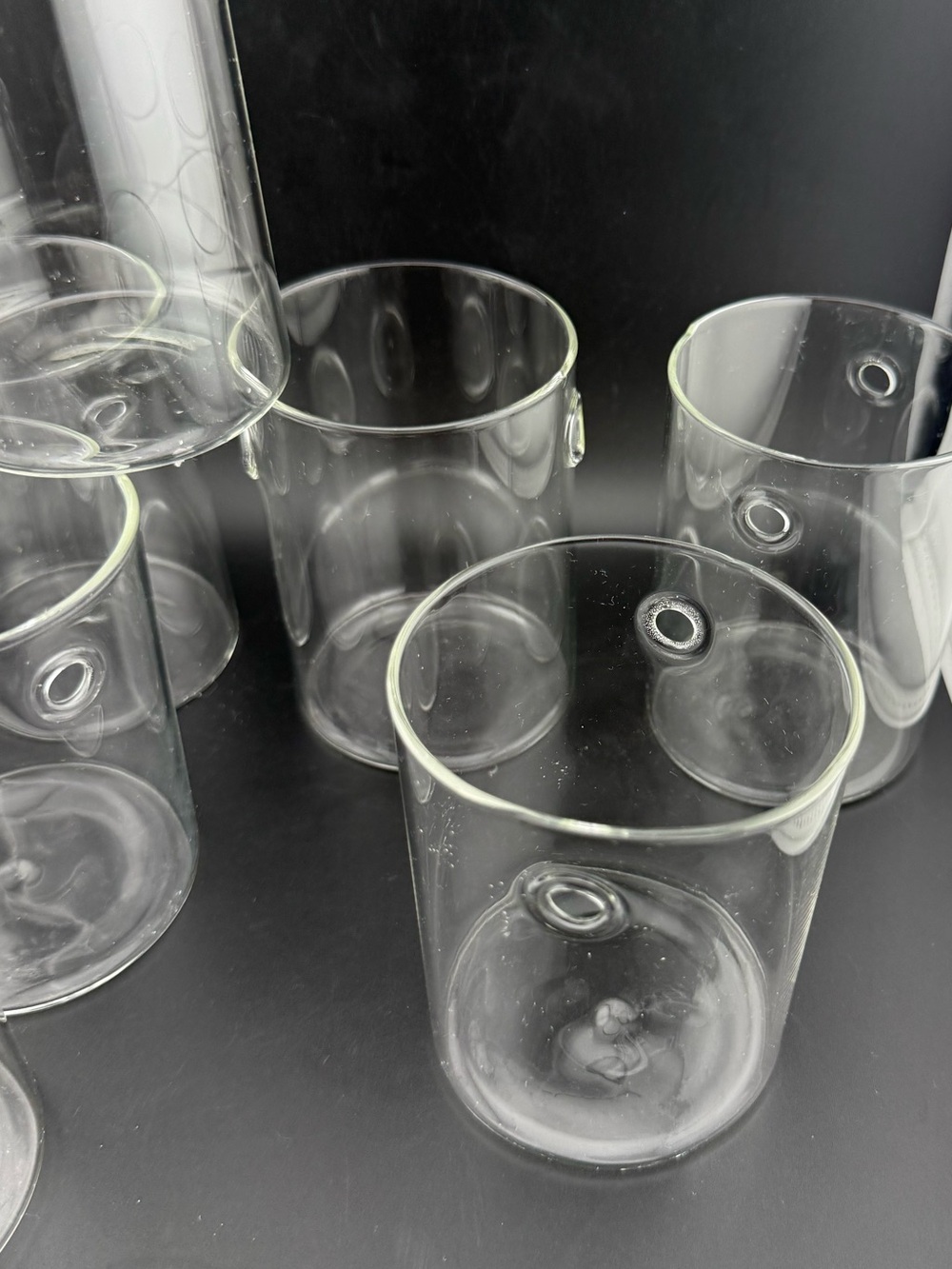6 glass cylinders/glasses/candle holders. 12oz to the holes.